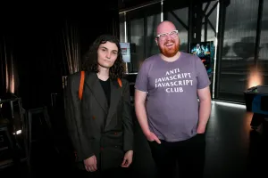 Two Astro core members, Erika and Nate, post together. Nate wears an, "Anti Javascript Javascript Club," t-shirt.