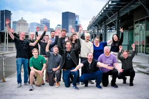 The Astro core team poses with their hands up outside the meetup venue with the Montreal skyline behind them.