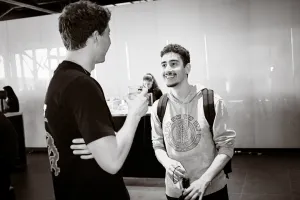 Black and white photos of two male guests chatting with one another.