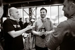 Black and white photo of Glauber, from Turso, speaking with Matthew, core contributor and framework lead at Astro, and an Astro core maintainer.