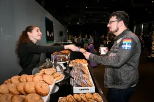 A guest being handed a gourmet cookie at the cookie bar.