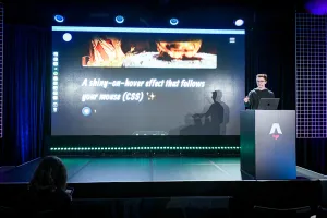 Ben Holmes on stage at the podium, sharing a demo for a shiny-on-hover effect that follows your mouse.