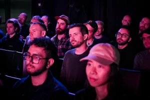 Audience members listening to Sarah Rainsberger speaking on stage.