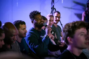 An audience member holding a microphone, asking keynote speakers a question.