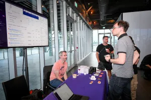 A guest speaks to Sentry at their sponsor booth.