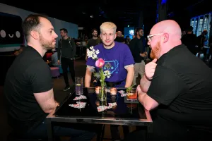 Astro team members chatting with their drinks at a high table.