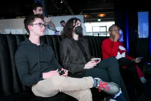 Ben Holmes, Erika Moreau, and Darius Tall (all from Astro) playing video games.