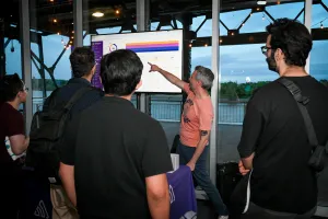 Sentry rep pointing to a chart on the TV screen at their sponsor booth.